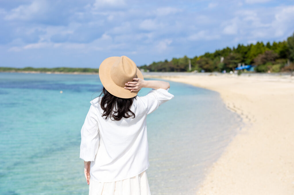 沖縄の浜辺を歩く女性