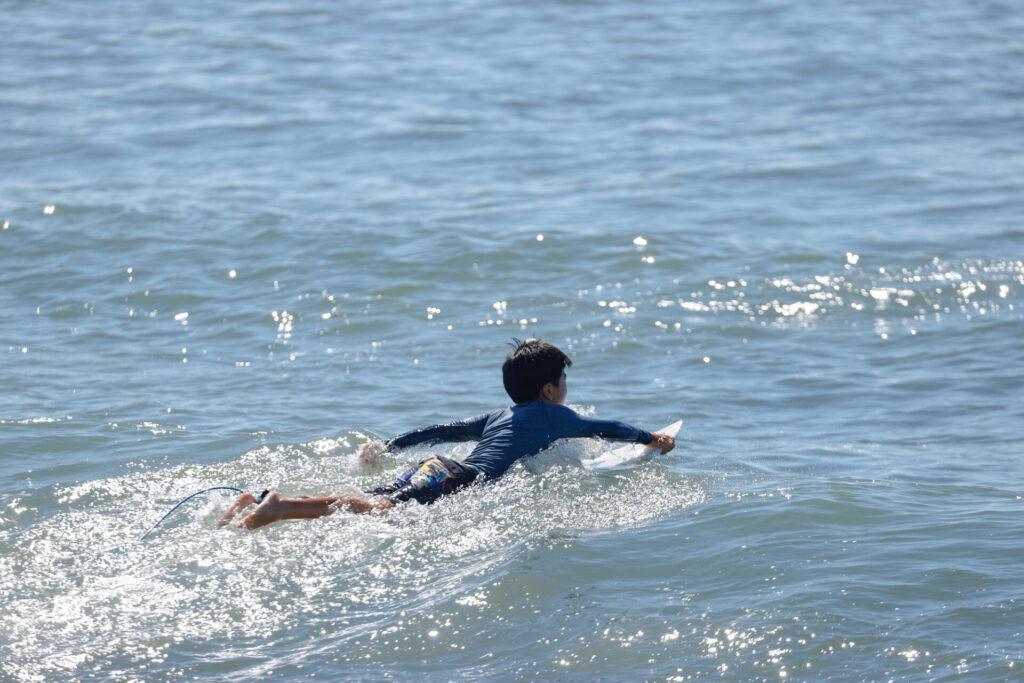 湘南の海でサーフィンをする少年