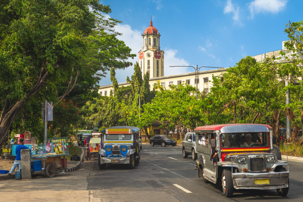 street view of manila with jeepney and clock tower 