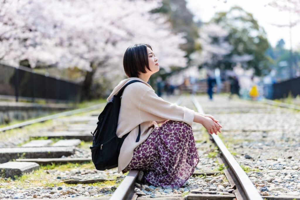 春の桜が美しい京都観光を楽しむ女性