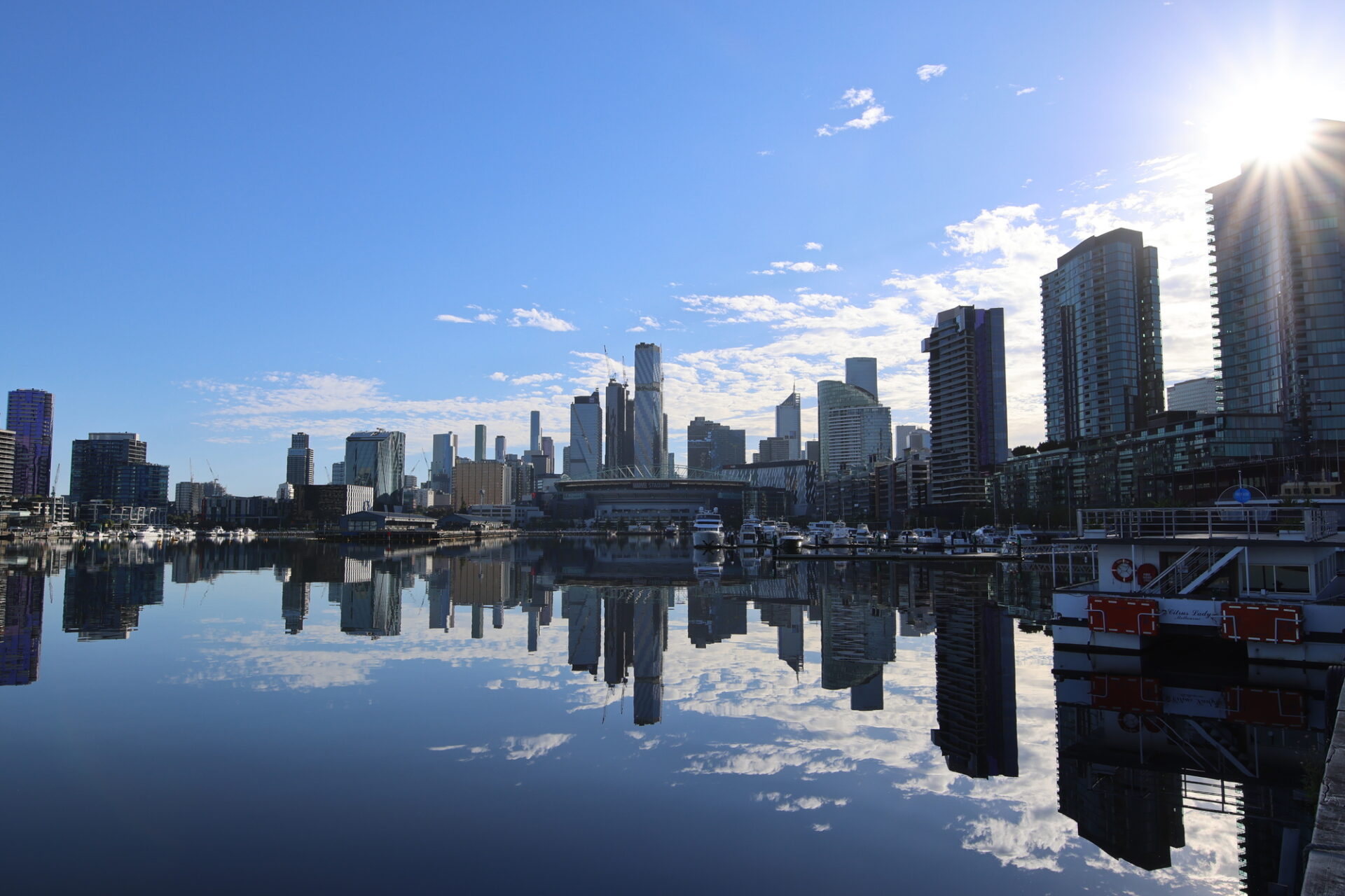 晴れた青空の水面に反射するオーストラリアメルボルンドックランズのビル群