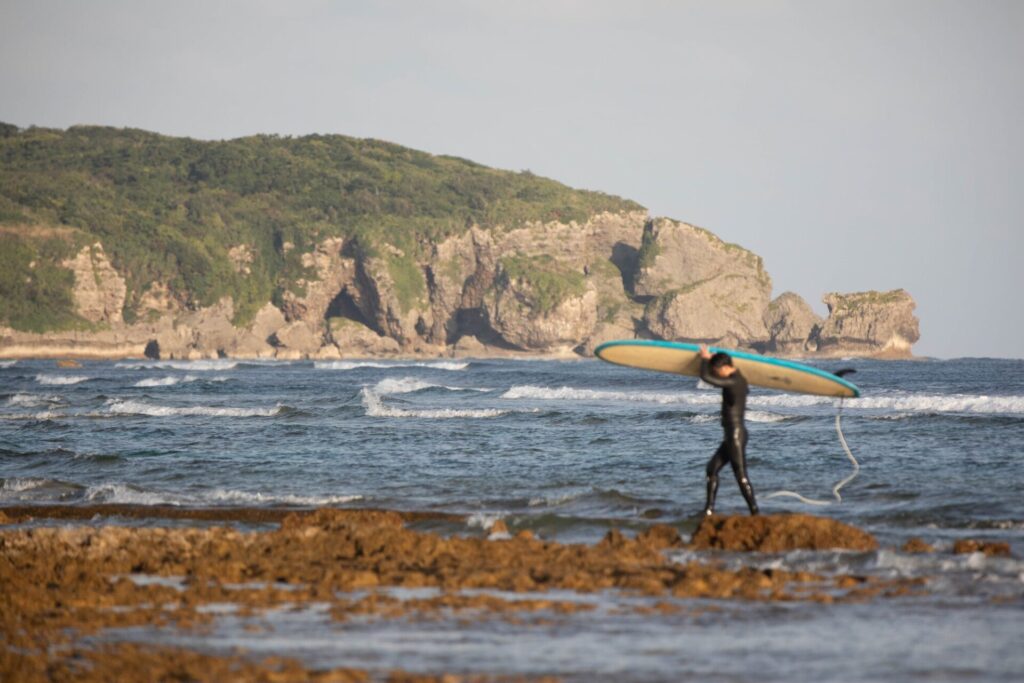 沖縄の海でサーフィンをするサーファー