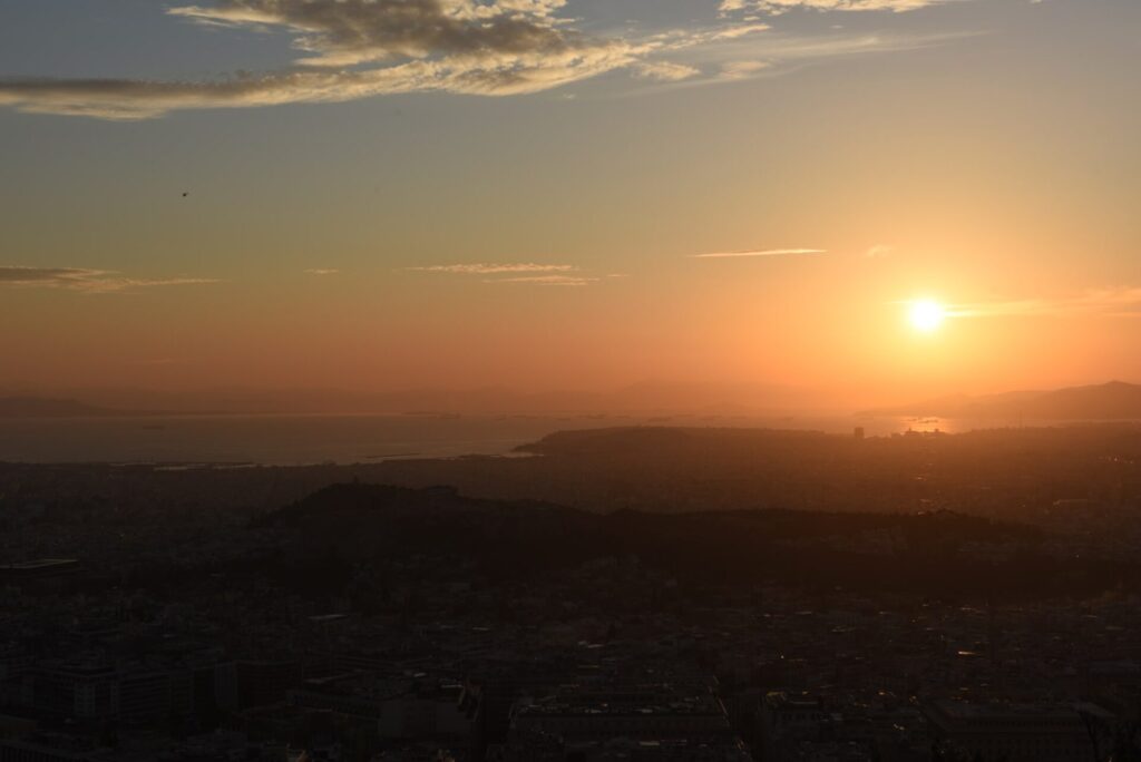 ギリシャのアテネのリカヴィトスの丘から観えるアクロポリス遺跡と夕日