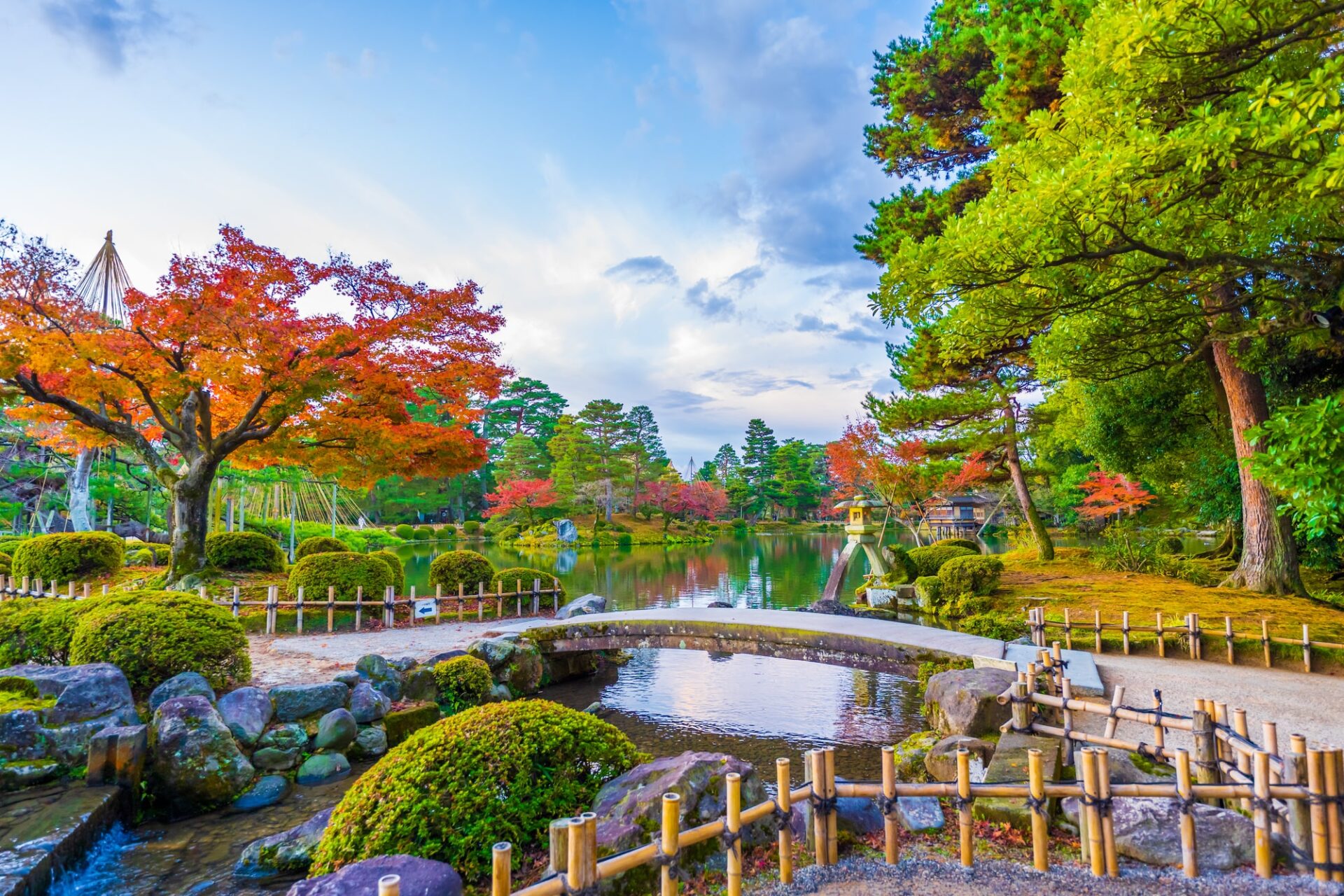 北陸の見どころ秋晴れの青空と紅葉が美しい兼六園霞ヶ池のことじ灯篭の風景