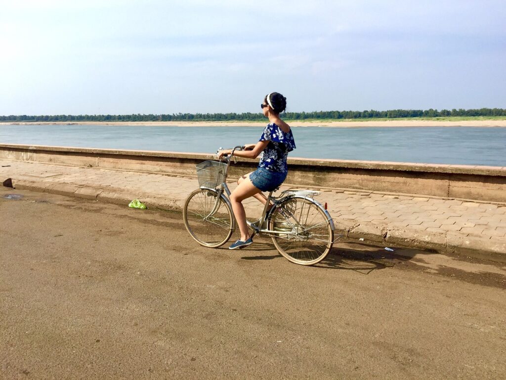 川沿いを自転車で走る人