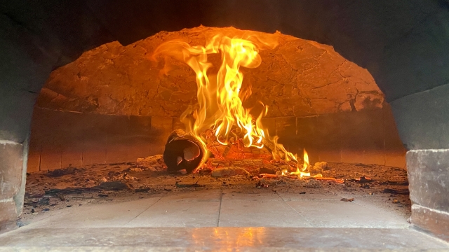 石窯の中で燃える薪と炎
