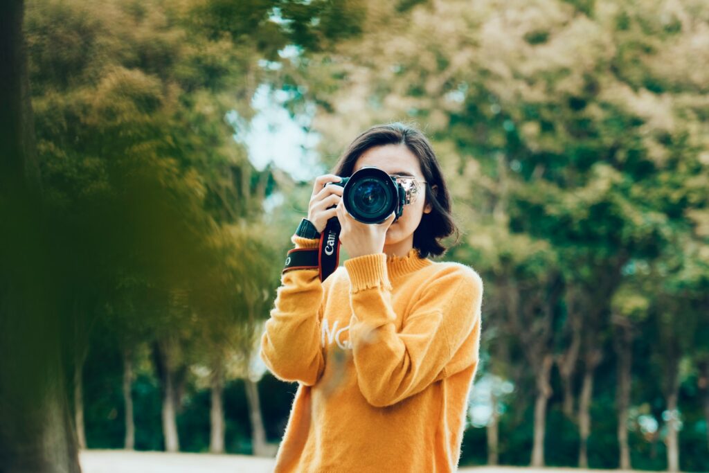 能古島を写真に収めるためにカメラをかまえる女性のイメージ