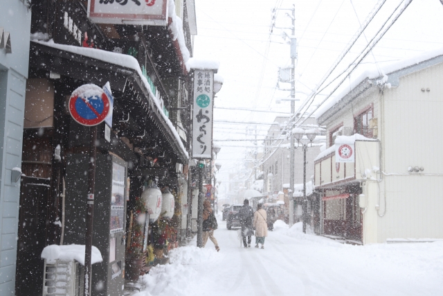 飛騨高山の雪深い町並みをいく人々