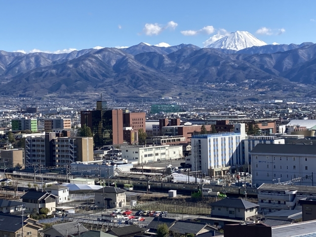 奥に富士山も見える甲府盆地の山々と市街地