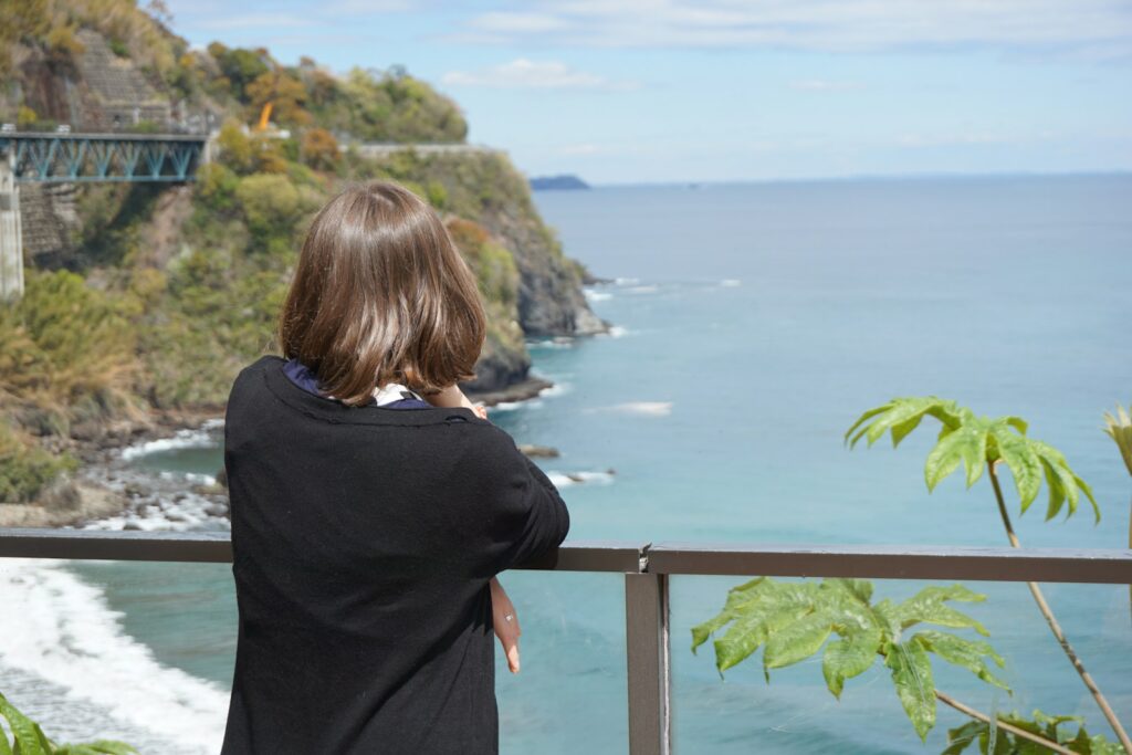 海を眺めてリラックスする女性