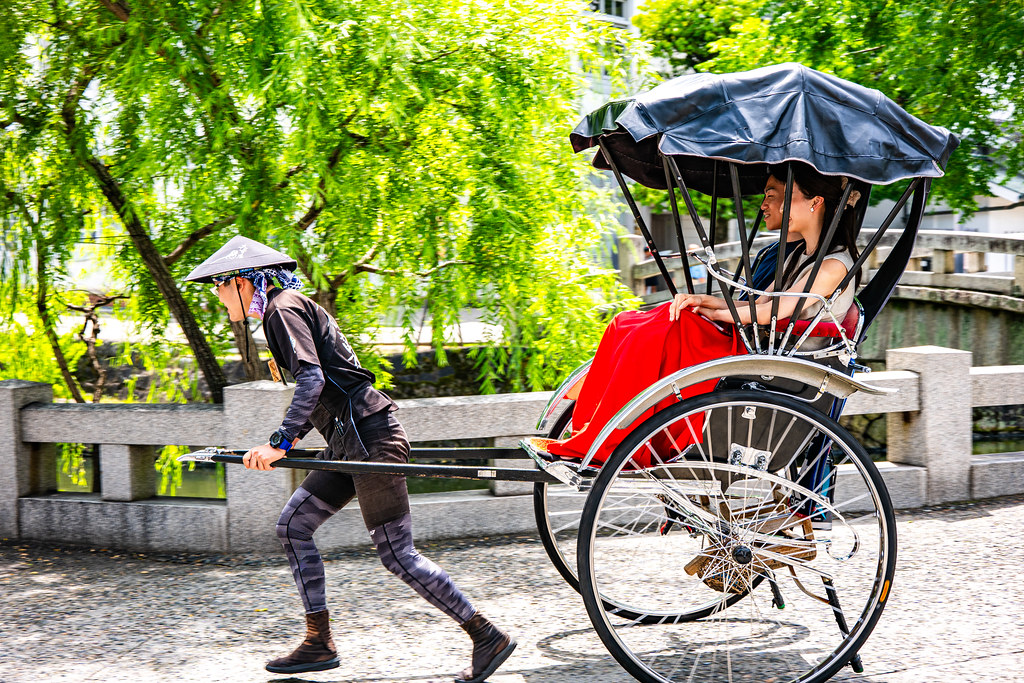 江戸時代の風情を感じながら人力車に乗る男女