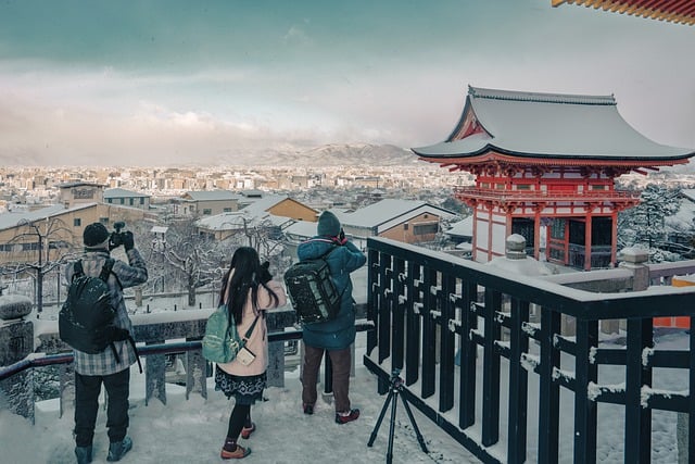 雪の清水寺を撮影する観光客の人々