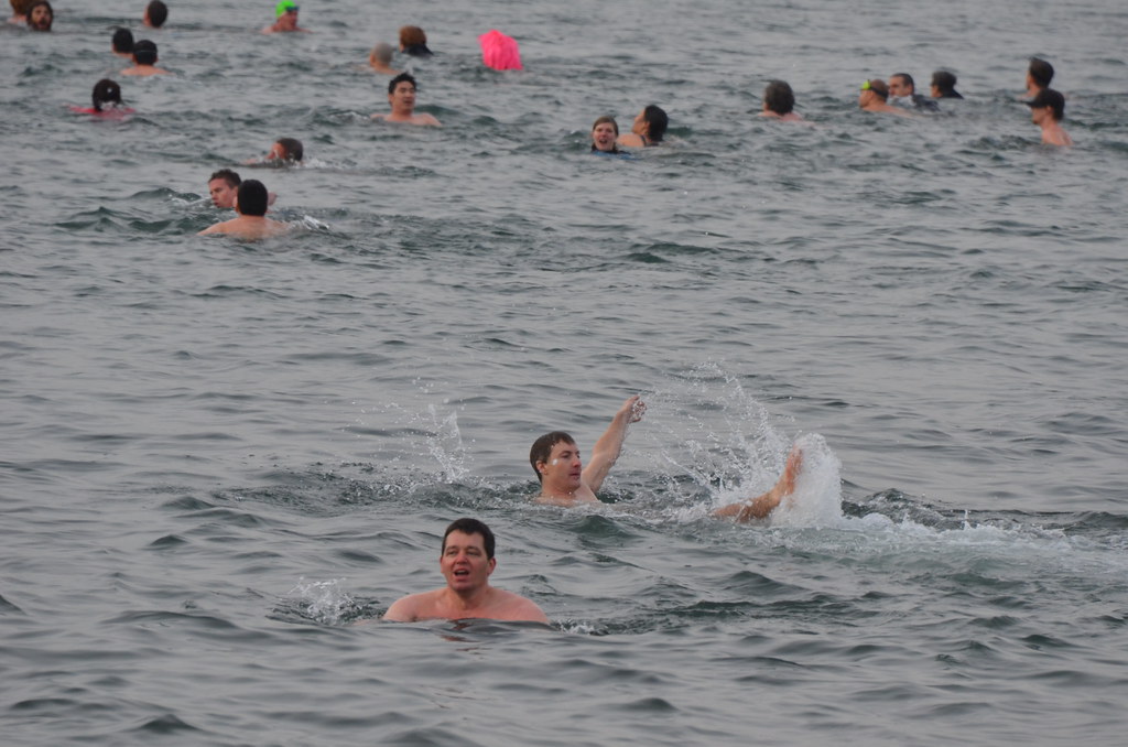 イングリッシュ湾の寒中水泳大会で泳ぐ人々