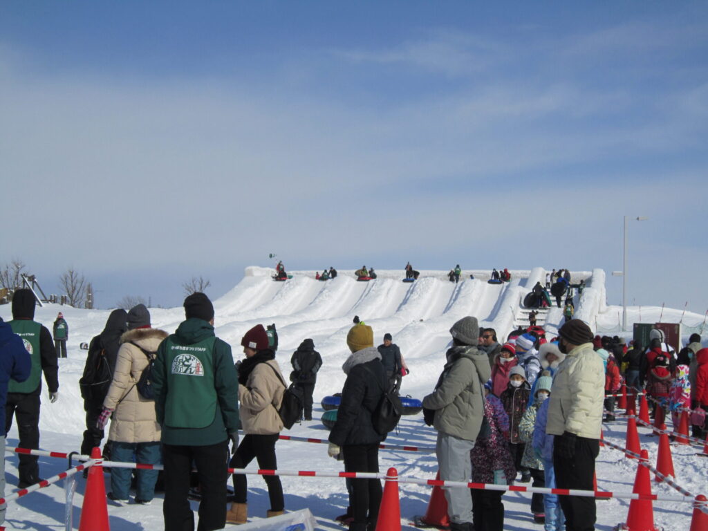 さっぽろ雪まつり、つどーむ会場のチューブスライダーを楽しむ人々