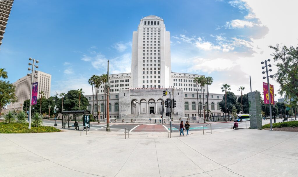 people walking on park near white concrete building during daytime