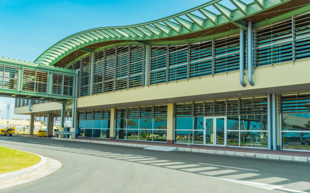 a large building with a green roof and a curved walkway