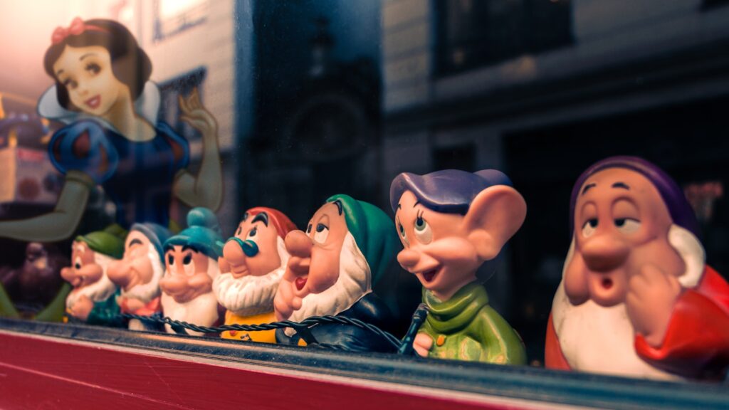 a row of snow white figurines sitting on top of a shelf