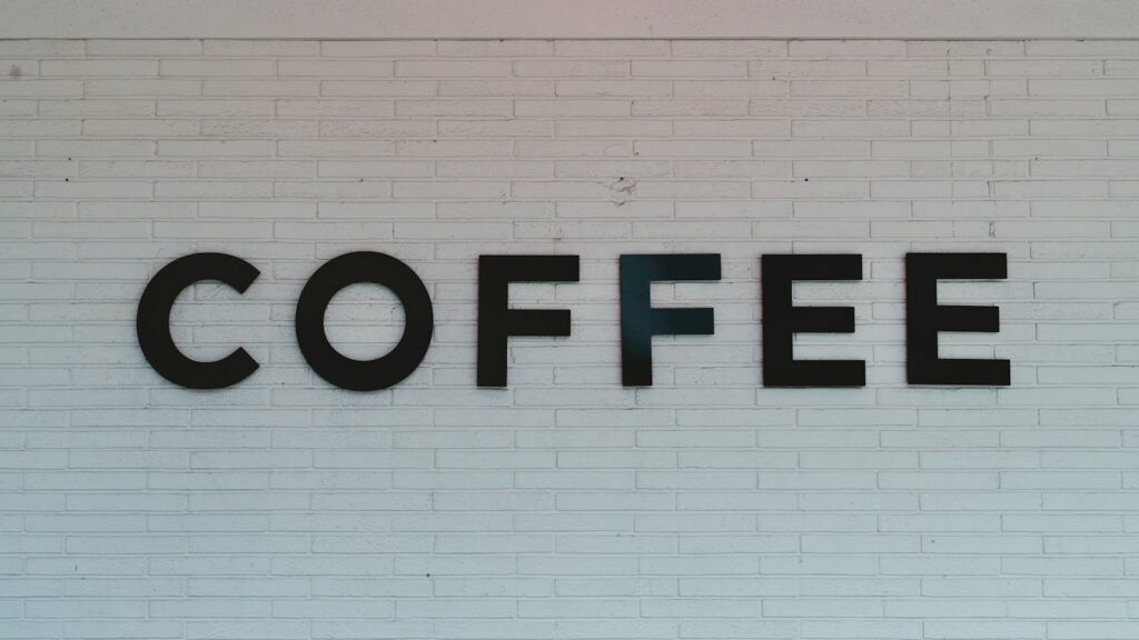 a white brick wall with a sign that says coffee