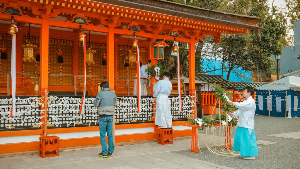 man in white dress shirt standing near brown wooden gate during daytime