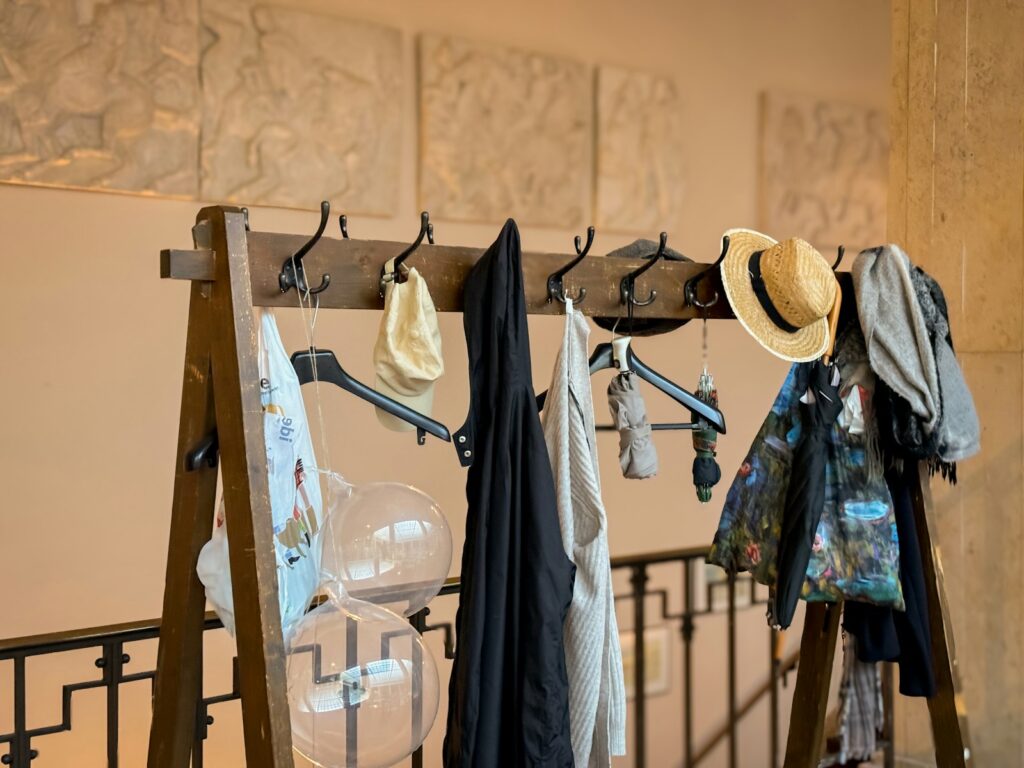 A coat rack with hats and scarves hanging on it